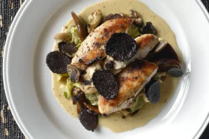 Bowl of black truffle chicken salad with herbs